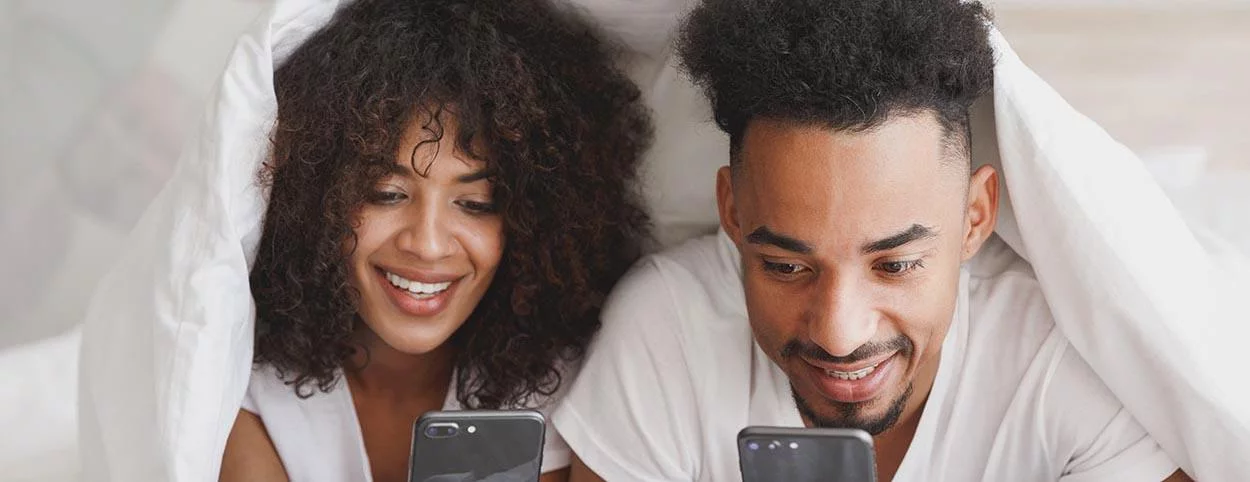 stel kijkt in bed op telefoon