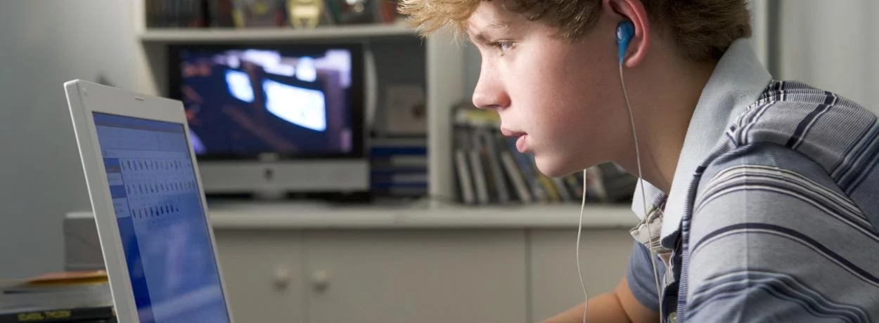 jongen kijkt op een laptop