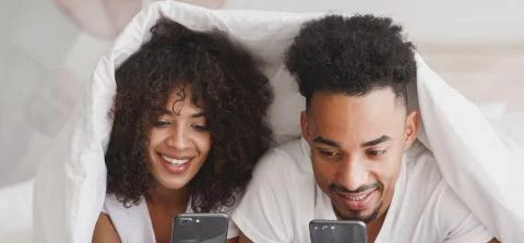 stel kijkt in bed op telefoon