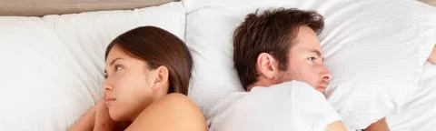 stel in bed met de ruggen naar elkaar toe
