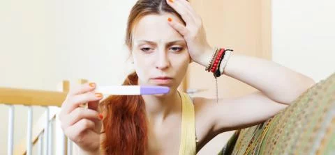 meisje kijkt naar zwangerschapstest