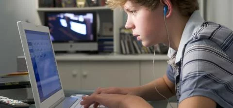 jongen kijkt op een laptop