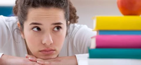 meisje kijkt naar een stapel boeken